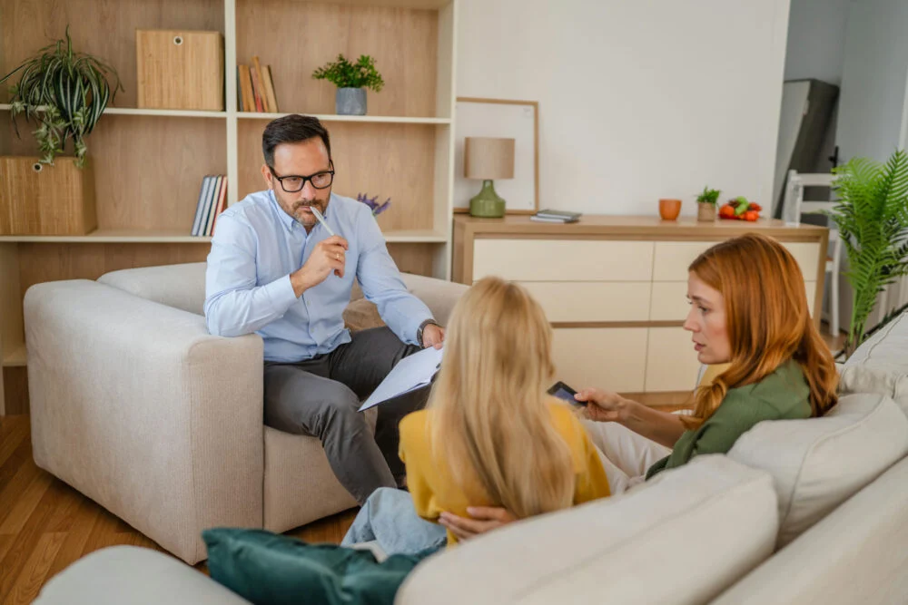 Therapist meeting with a teen and parent in a counseling session, illustrating Case Management for Teen mental health and coordinated family support.