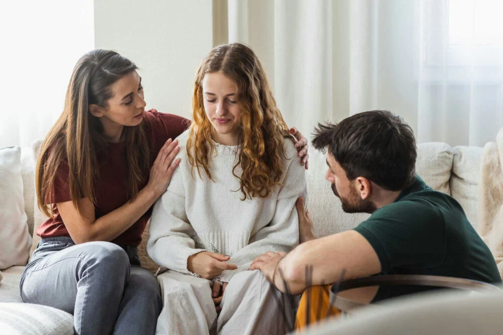 Parents providing emotional support to a teen at home, representing compassionate Case Management for Teen mental health and family involvement.