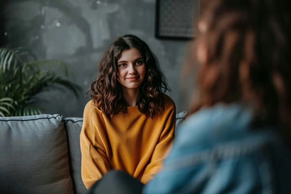 teen girl with therapist practicing self-esteem affirmations in session