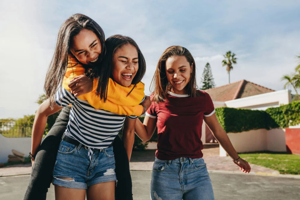 group of happy teens enjoying summer activities