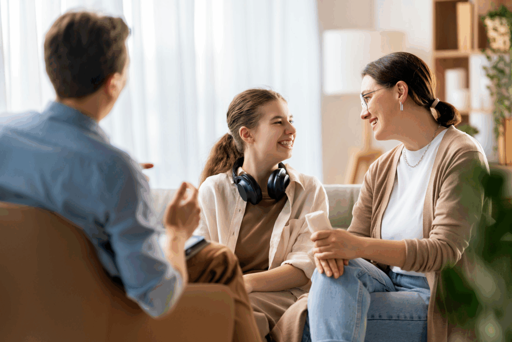 a mom with teenage daughter smiling in therapy