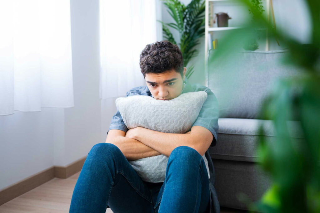 a teen grieving holding a pillow