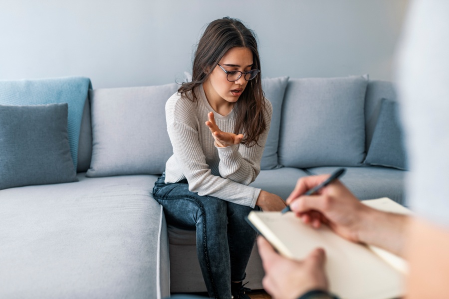 a-teen-girl-sitting-on-couch-speaking-in-therapy